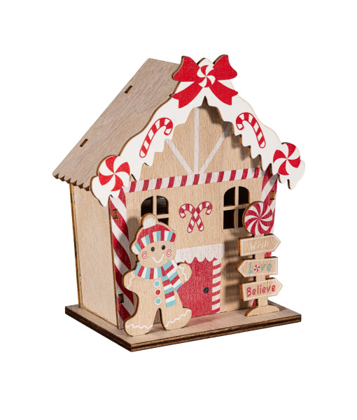 Maison en pain d'épice en bois éclairée, avec un petit garçon en pain d'épice.