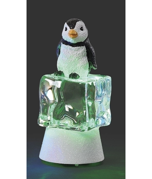 Pièce de table, pingouin illuminé par une lumière scintillante sur un cube de glace vert
